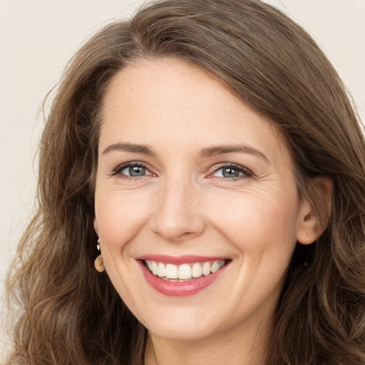 Joyful white adult female with long  brown hair and brown eyes