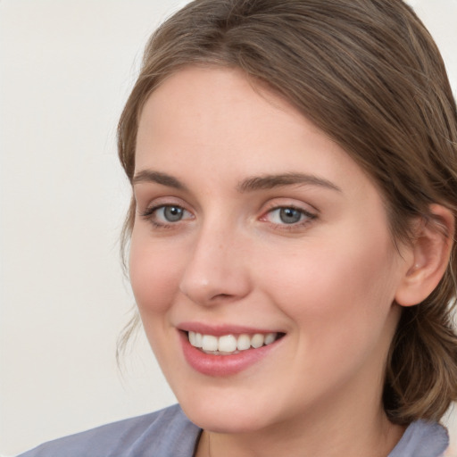 Joyful white young-adult female with medium  brown hair and blue eyes