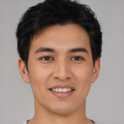 Joyful asian young-adult male with short  black hair and brown eyes