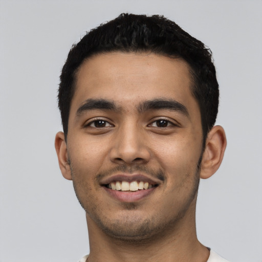 Joyful latino young-adult male with short  black hair and brown eyes