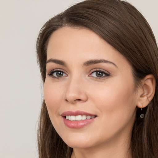 Joyful white young-adult female with long  brown hair and brown eyes