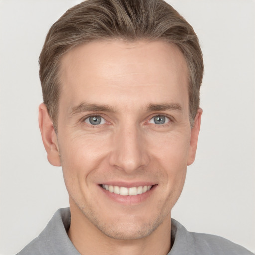 Joyful white adult male with short  brown hair and grey eyes