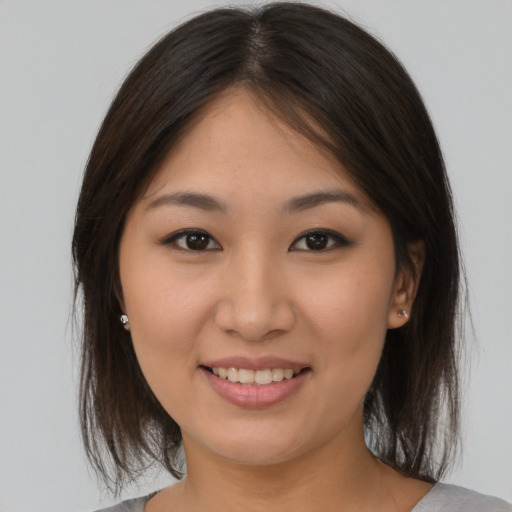 Joyful asian young-adult female with medium  brown hair and brown eyes