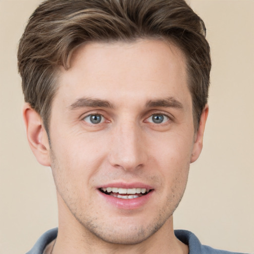 Joyful white young-adult male with short  brown hair and grey eyes