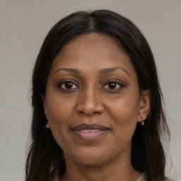 Joyful black adult female with long  brown hair and brown eyes