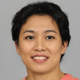 Joyful asian young-adult female with short  brown hair and brown eyes