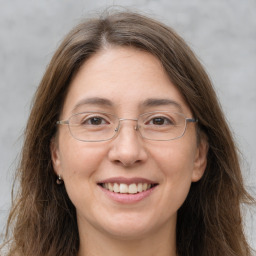 Joyful white adult female with long  brown hair and grey eyes