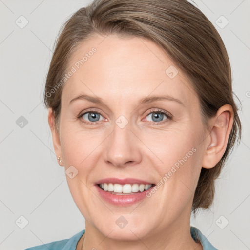 Joyful white adult female with medium  brown hair and blue eyes