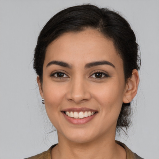 Joyful latino young-adult female with medium  brown hair and brown eyes