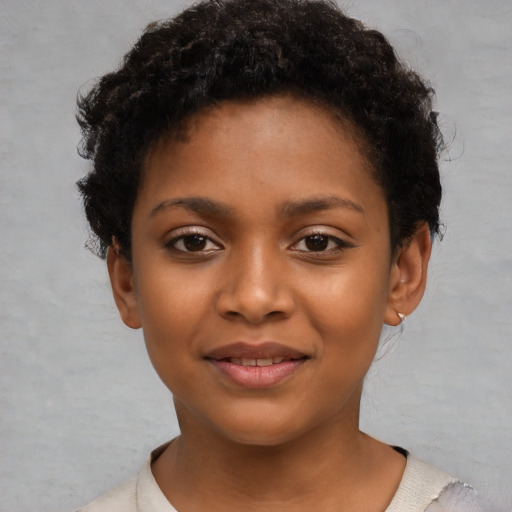 Joyful black child female with short  brown hair and brown eyes