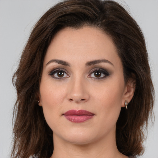 Joyful white young-adult female with long  brown hair and brown eyes