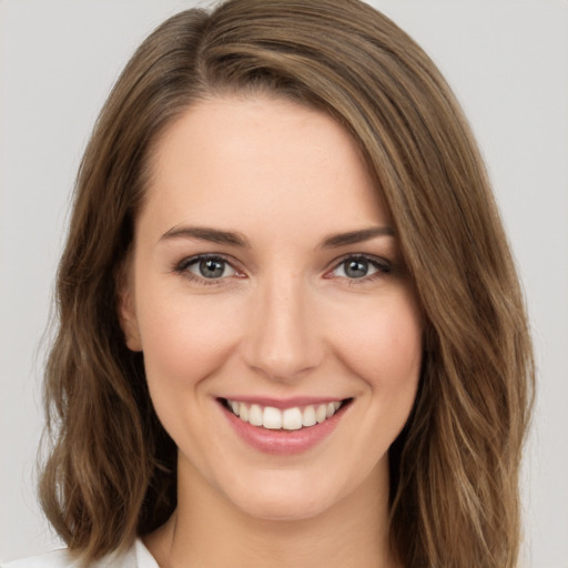 Joyful white young-adult female with long  brown hair and green eyes