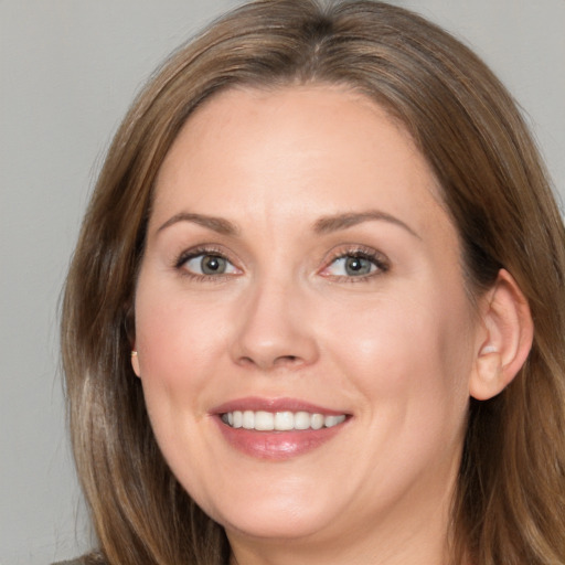 Joyful white adult female with long  brown hair and brown eyes