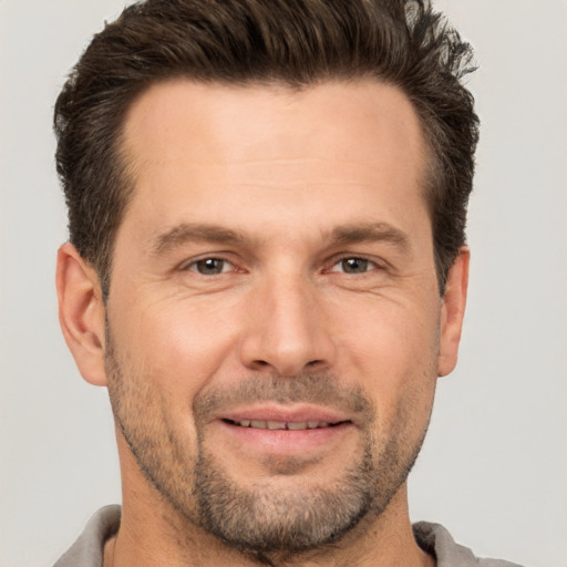 Joyful white adult male with short  brown hair and brown eyes