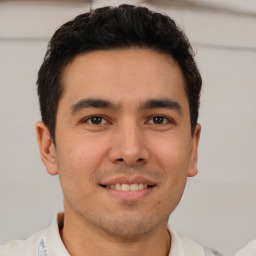 Joyful latino young-adult male with short  brown hair and brown eyes