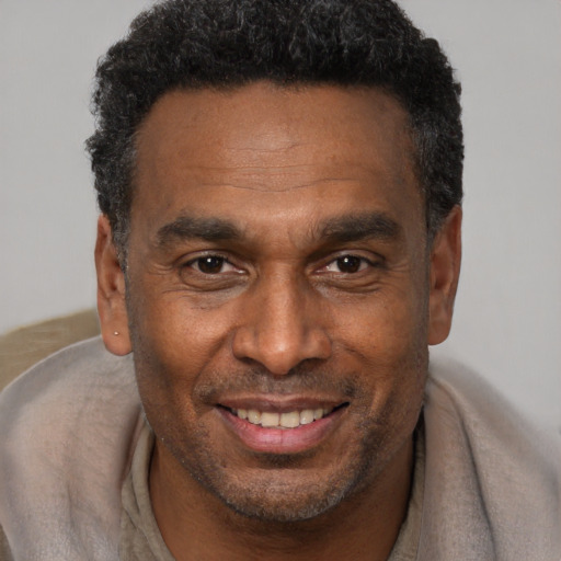 Joyful black adult male with short  brown hair and brown eyes