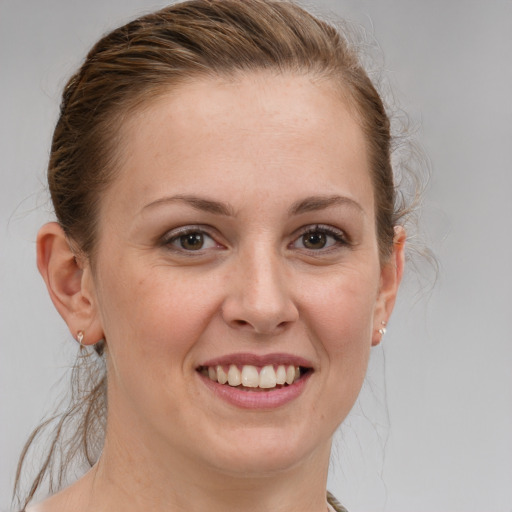 Joyful white young-adult female with medium  brown hair and grey eyes