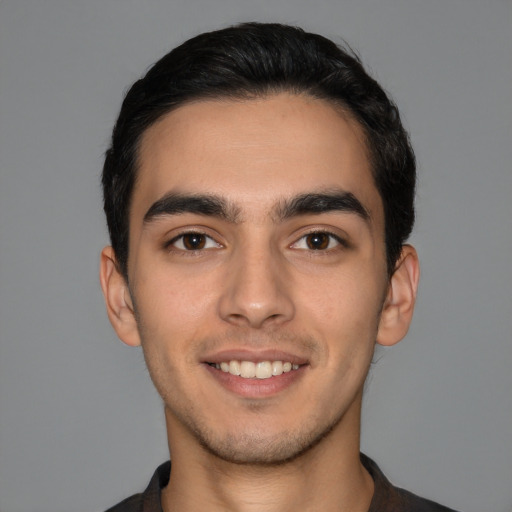 Joyful latino young-adult male with short  black hair and brown eyes