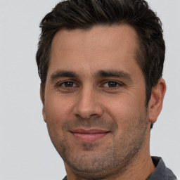 Joyful white adult male with short  brown hair and brown eyes