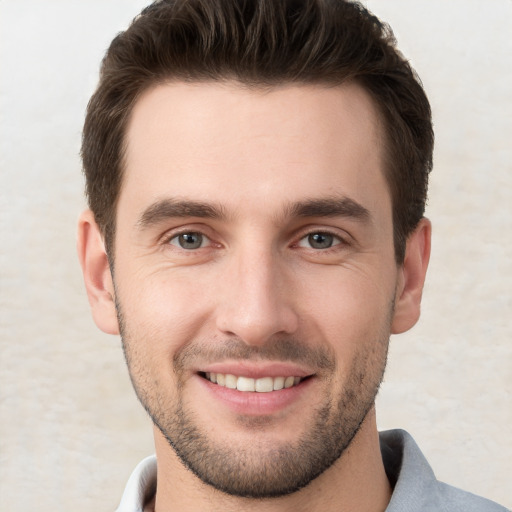 Joyful white young-adult male with short  brown hair and brown eyes