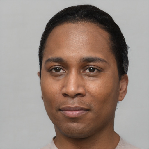 Joyful black young-adult male with short  black hair and brown eyes