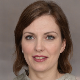 Joyful white adult female with medium  brown hair and grey eyes