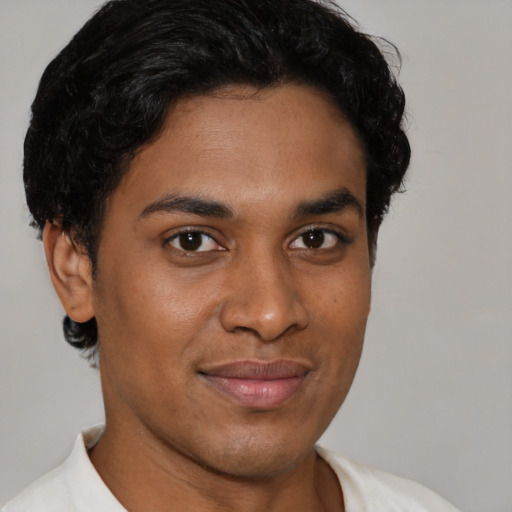 Joyful latino young-adult male with short  brown hair and brown eyes