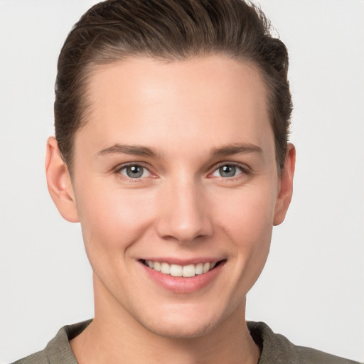 Joyful white young-adult female with short  brown hair and grey eyes