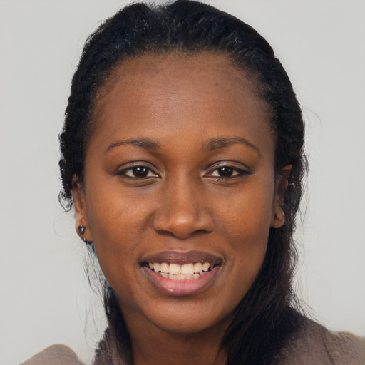 Joyful black adult female with long  black hair and brown eyes