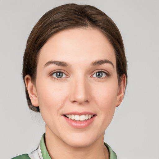 Joyful white young-adult female with medium  brown hair and green eyes