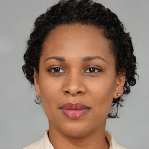 Joyful black young-adult female with short  brown hair and brown eyes