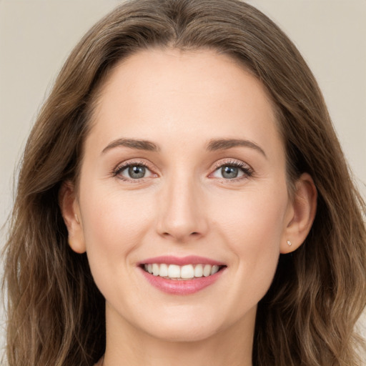 Joyful white young-adult female with long  brown hair and green eyes