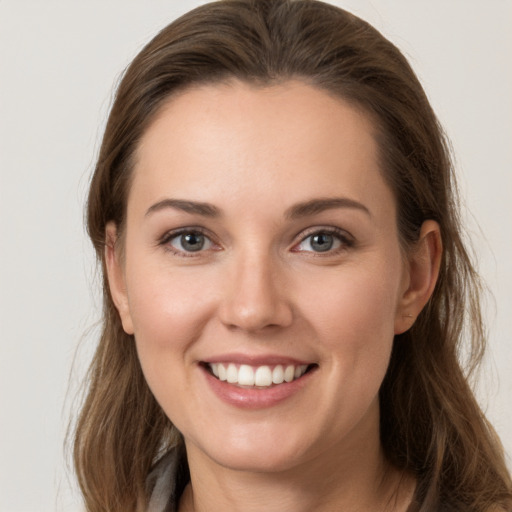 Joyful white young-adult female with long  brown hair and grey eyes