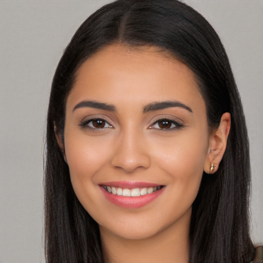 Joyful latino young-adult female with long  brown hair and brown eyes