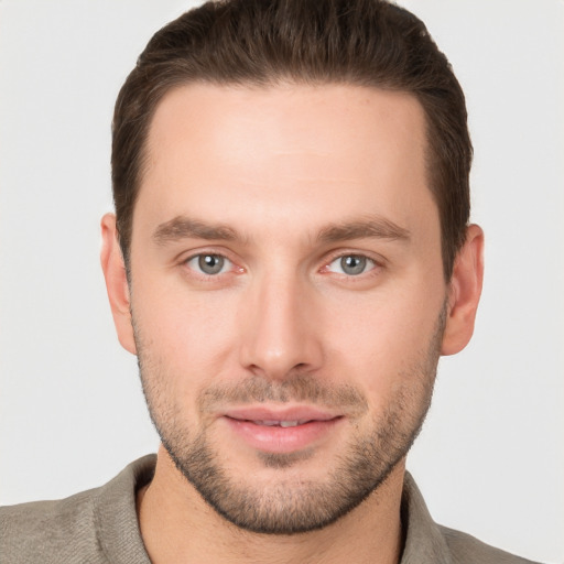 Joyful white young-adult male with short  brown hair and grey eyes