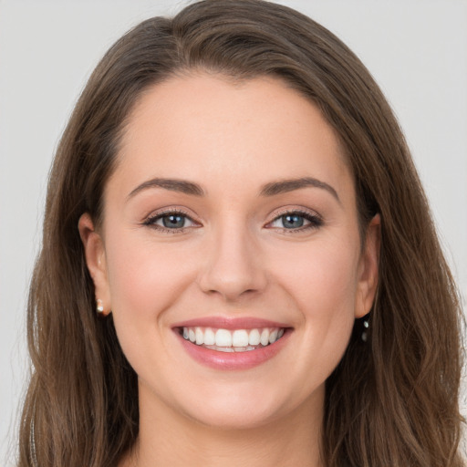 Joyful white young-adult female with long  brown hair and grey eyes