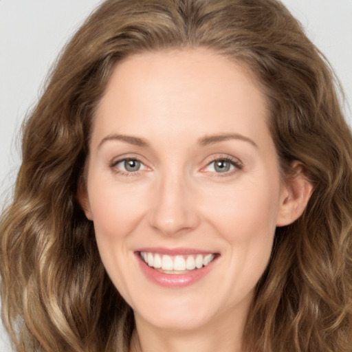 Joyful white young-adult female with long  brown hair and green eyes