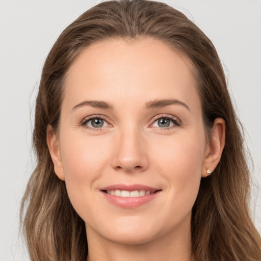 Joyful white young-adult female with long  brown hair and grey eyes