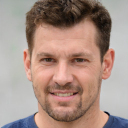 Joyful white adult male with short  brown hair and grey eyes