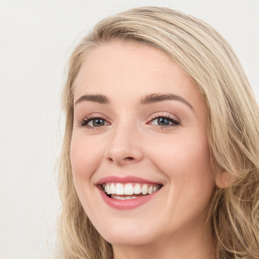 Joyful white young-adult female with long  brown hair and blue eyes