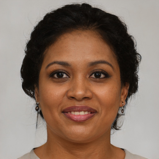 Joyful black young-adult female with medium  brown hair and brown eyes