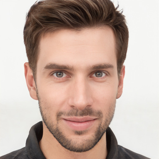 Joyful white young-adult male with short  brown hair and grey eyes