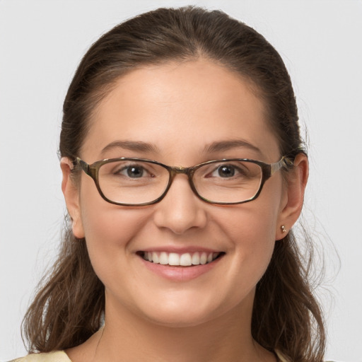 Joyful white young-adult female with long  brown hair and grey eyes