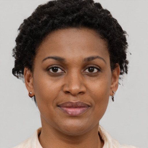 Joyful black young-adult female with short  brown hair and brown eyes