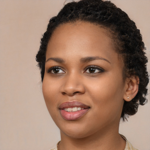Joyful black young-adult female with long  black hair and brown eyes