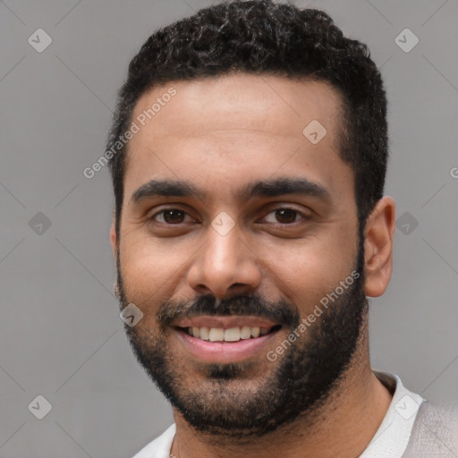 Joyful black young-adult male with short  black hair and brown eyes