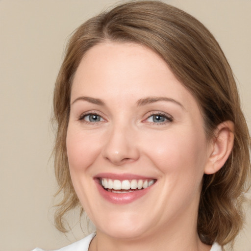 Joyful white young-adult female with medium  brown hair and blue eyes