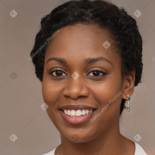 Joyful black young-adult female with long  black hair and brown eyes