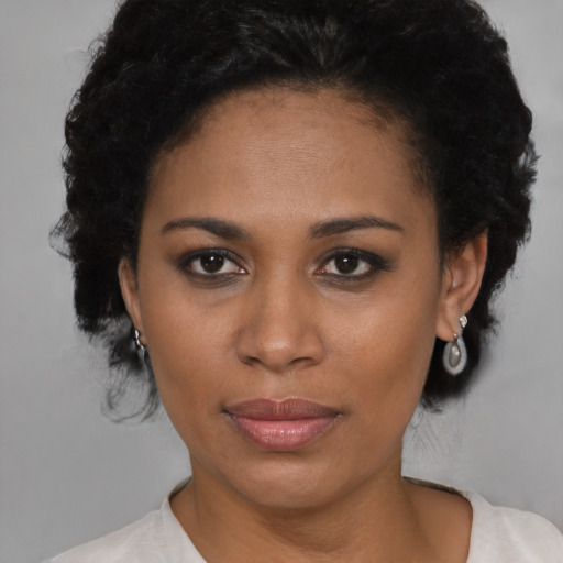 Joyful black young-adult female with short  black hair and brown eyes