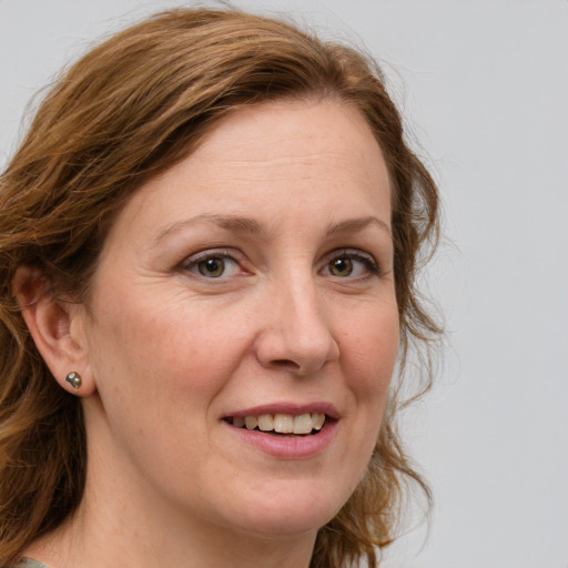 Joyful white adult female with medium  brown hair and green eyes